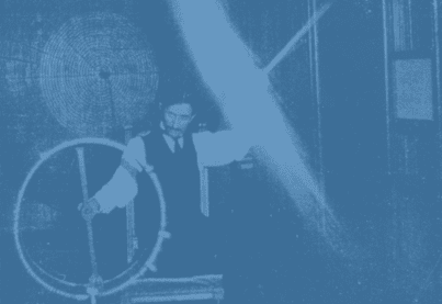 a person in a vest and tie holding a steering wheel